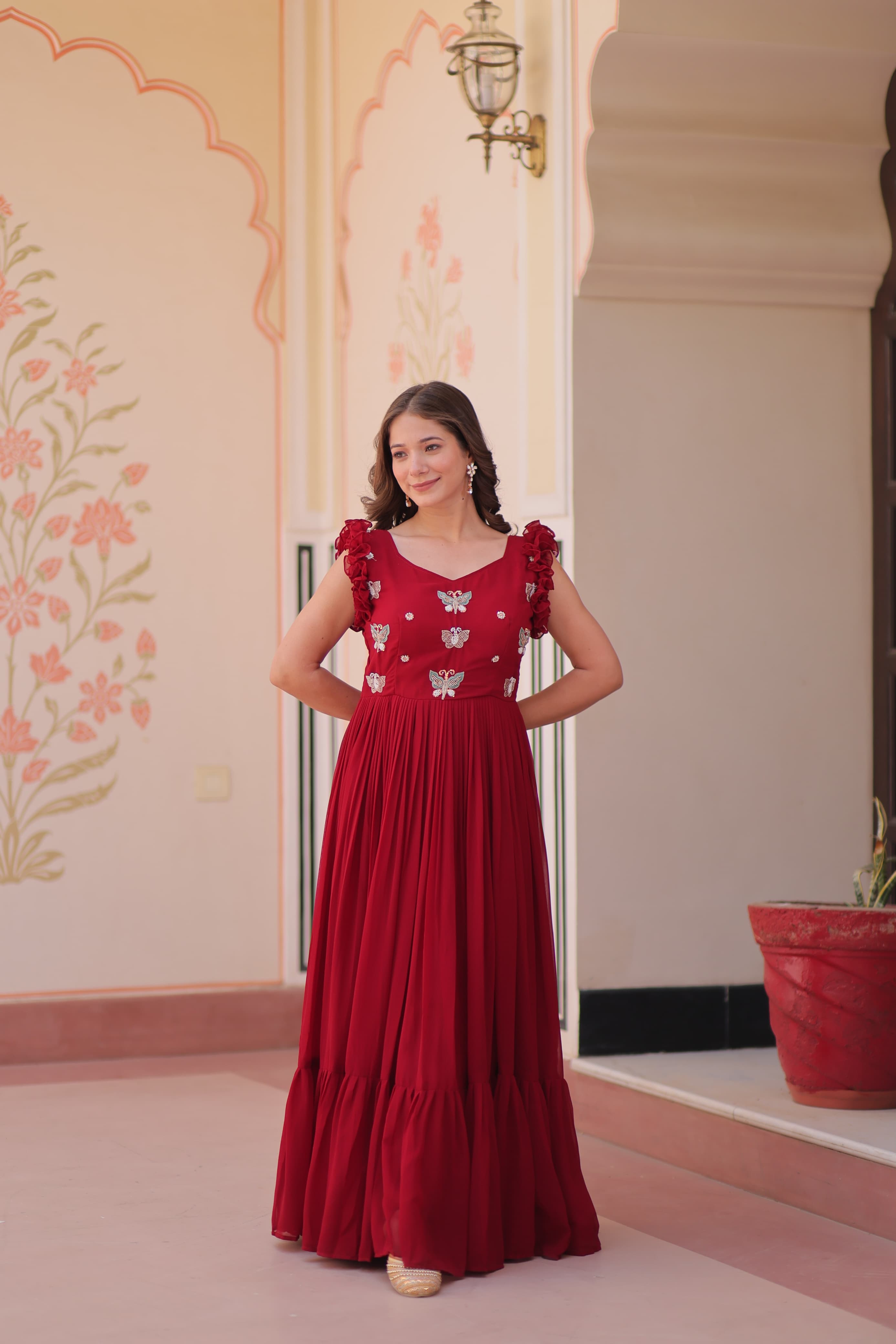 Woman wearing a red dress with floral patterns in an indoor setting