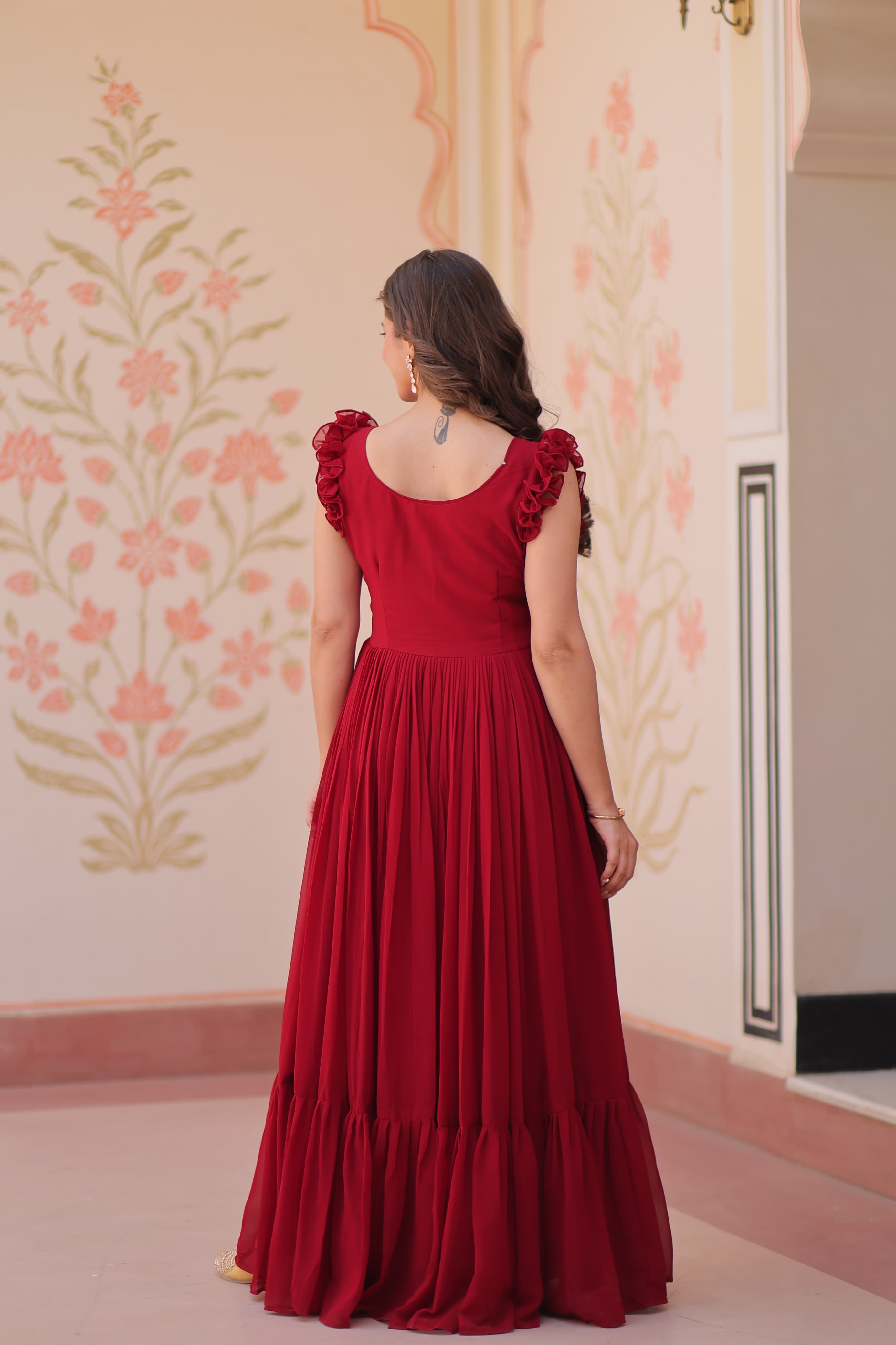 Woman wearing a red dress with floral wallpaper in the background