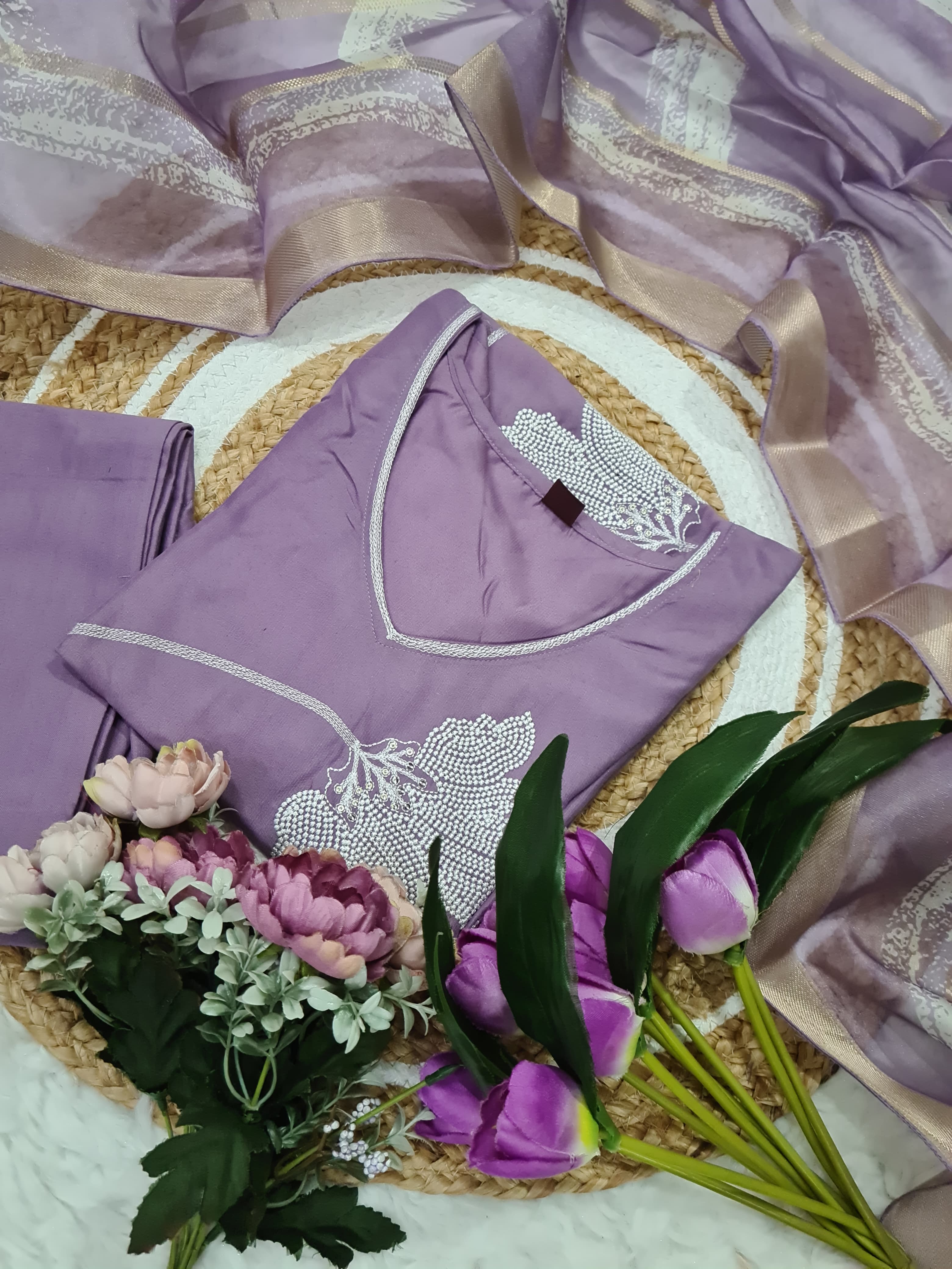 Purple lingerie set with floral decorations on a textured surface